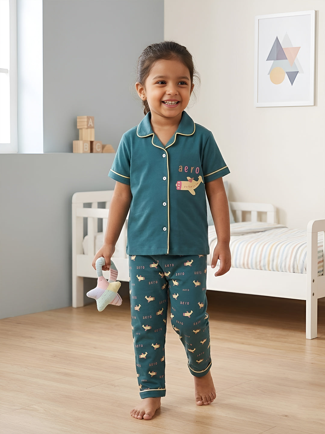 Child wearing teal pajamas with animal prints in a bedroom setting