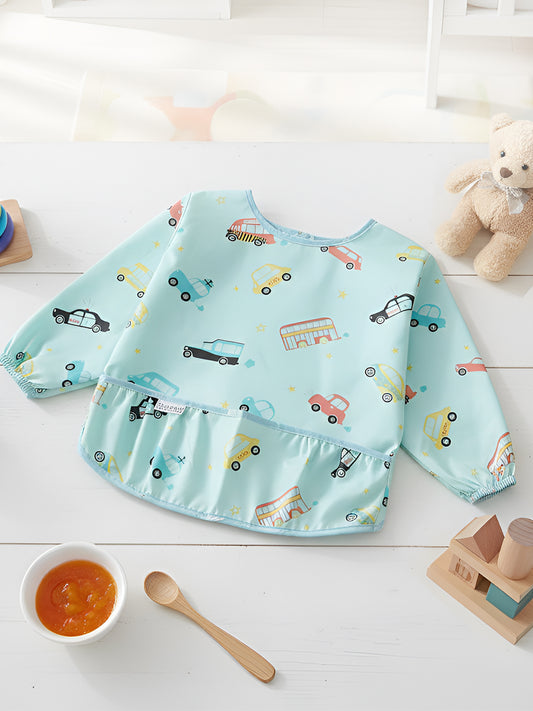 Children's apron with car pattern on a white surface with toys and a bowl.