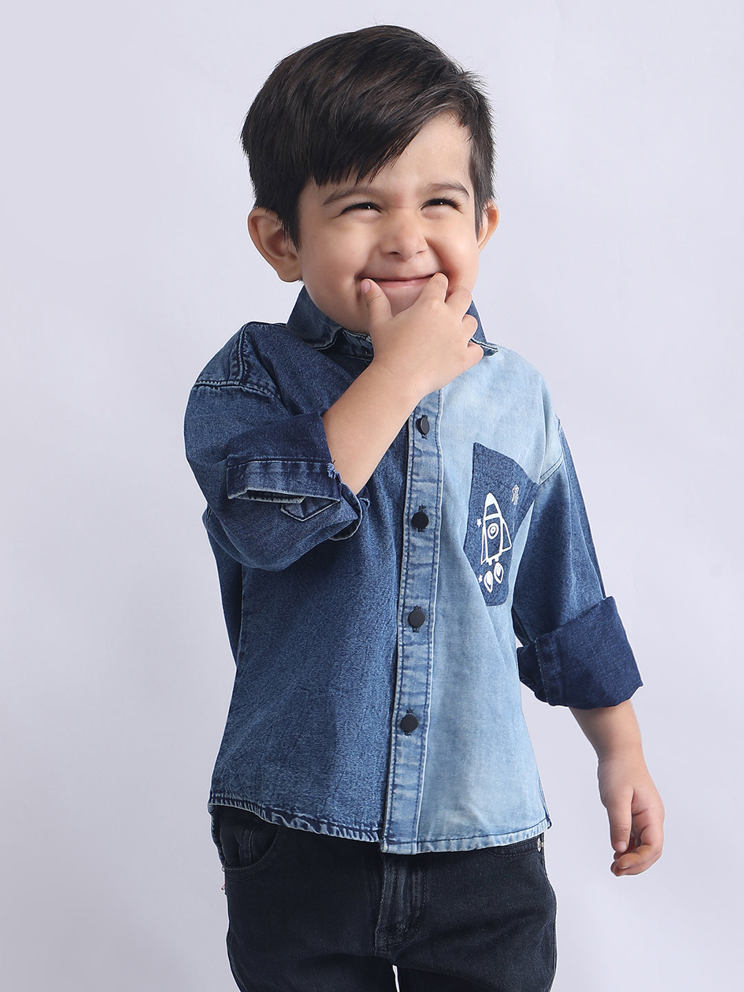 Child wearing a blue denim shirt with a graphic design on a white background
