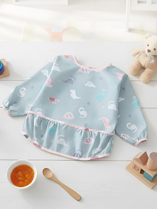 Baby bib with animal pattern on a white surface with toys and a bowl of food.