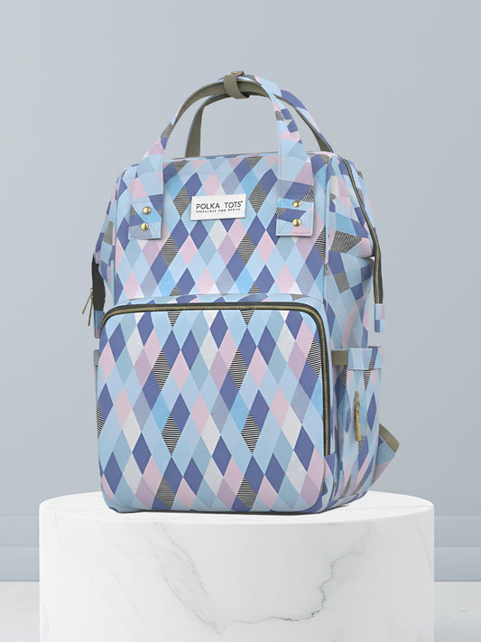 Backpack with blue and pink diamond pattern on a white pedestal against a light gray background
