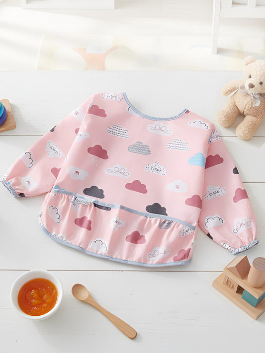 Pink baby bib with cloud and heart pattern on a white surface with toys and a bowl.