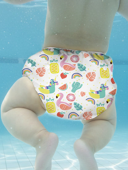 Colorful swim diaper with cartoon designs on a toy figure against a water background