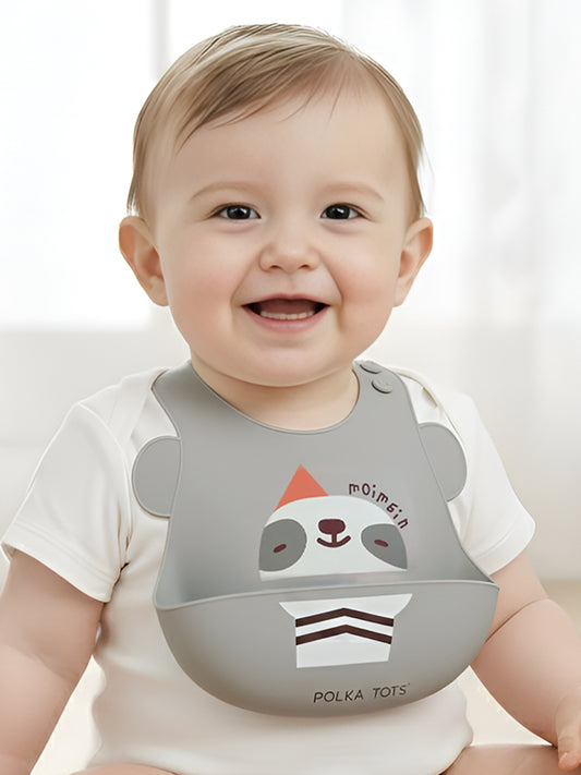 Baby wearing a bib with a cartoon design on a white background