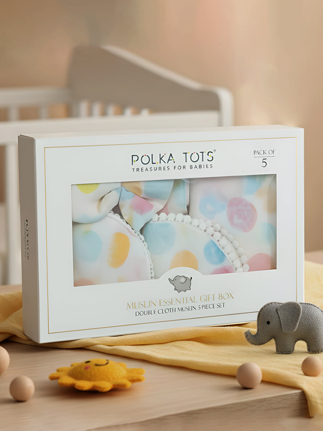 Polka Tots baby product packaging with a crib and toys in the background