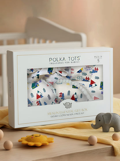 Polka Tots baby muslin essential gift box with baby toys on a wooden surface