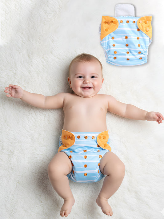 Baby wearing a blue diaper with orange accents on a white blanket