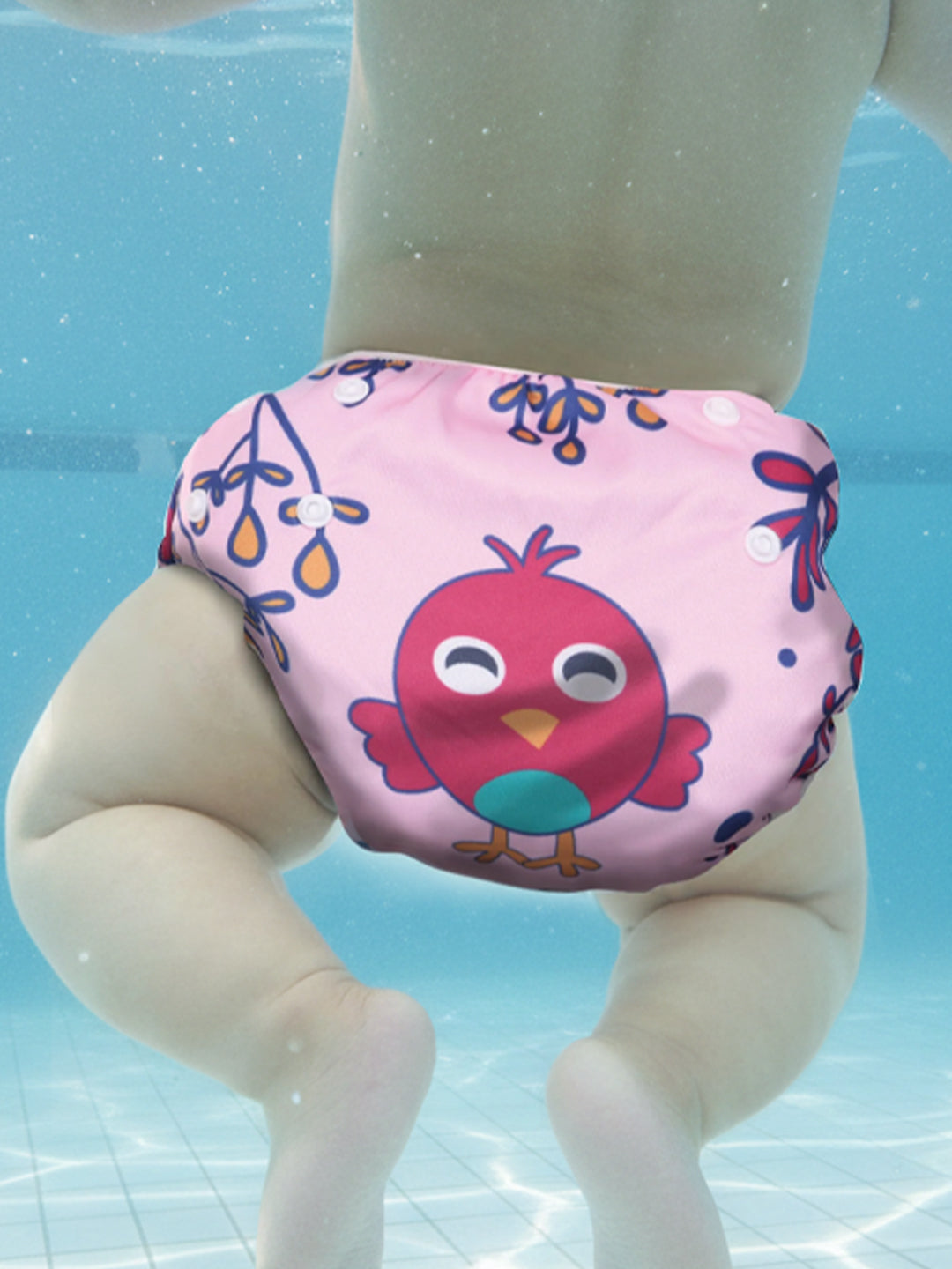 Pink swim diaper with a cartoon bird design worn by a child underwater.