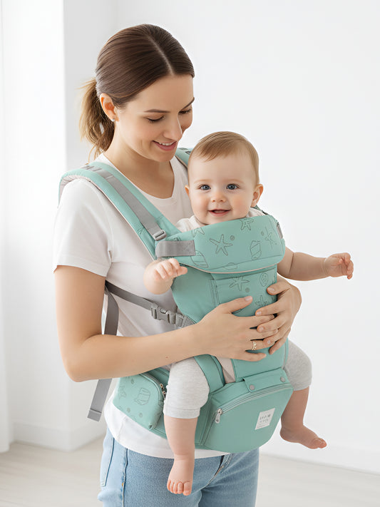 Woman holding a baby in a green baby carrier against a white background