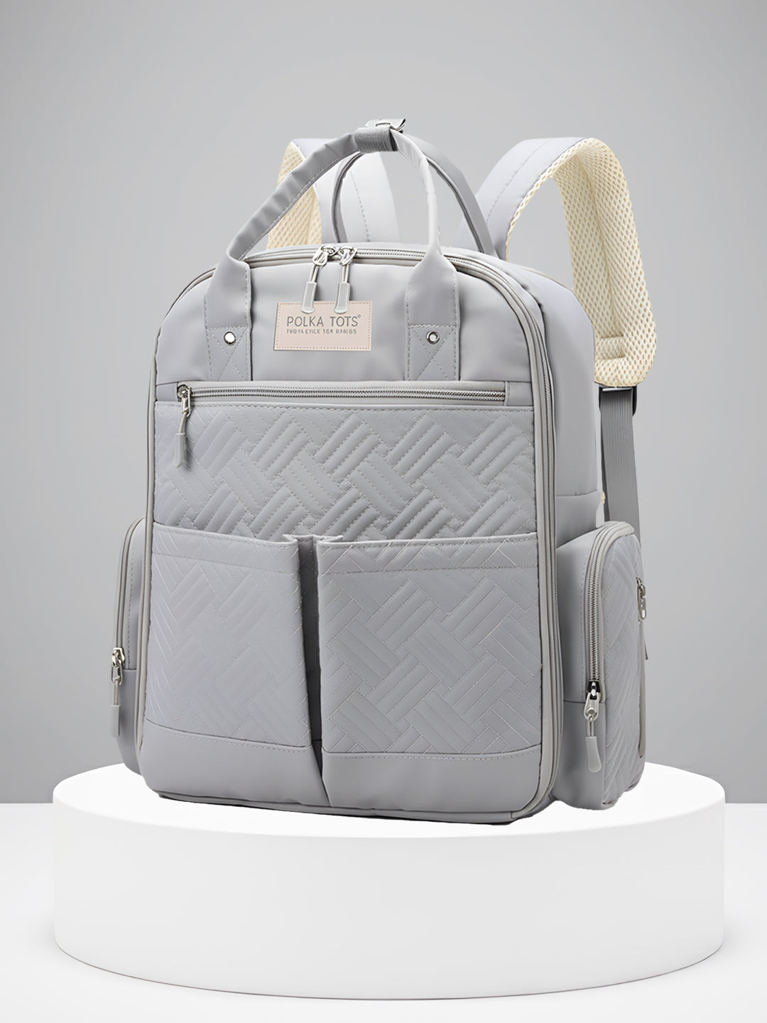 Gray backpack with quilted design on a white platform against a gray background