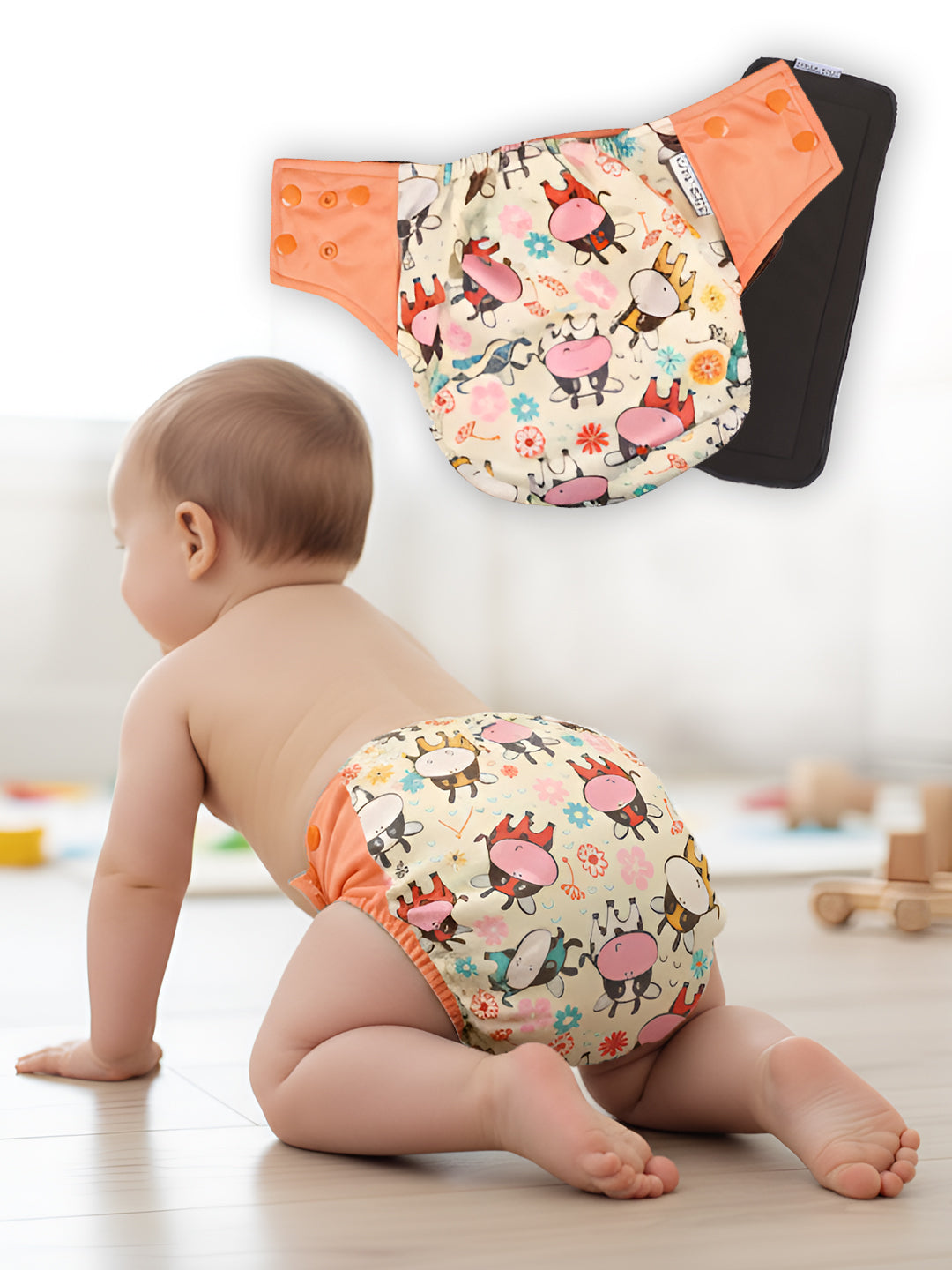 Baby wearing a colorful diaper with cartoon designs on a light wooden floor.