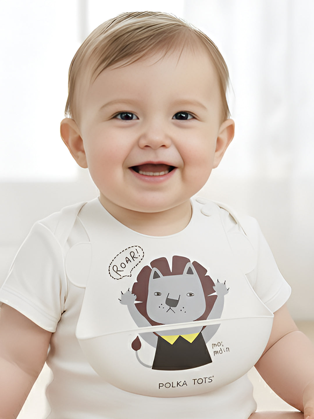 Baby wearing a white onesie with a lion design and 'Polka Tots' branding.