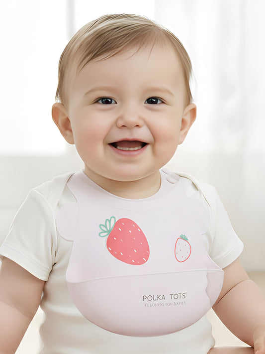 Baby wearing a bib with strawberry design and 'Polka Tots' branding