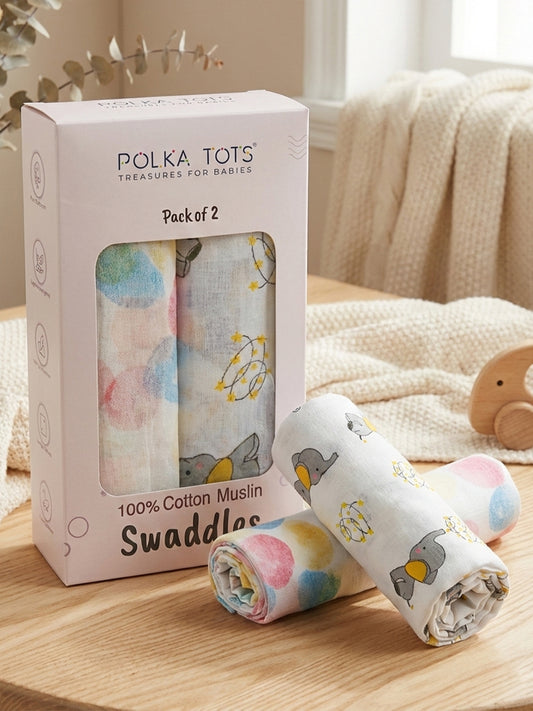 Polka Tots baby swaddles packaging with two swaddles on a wooden surface.