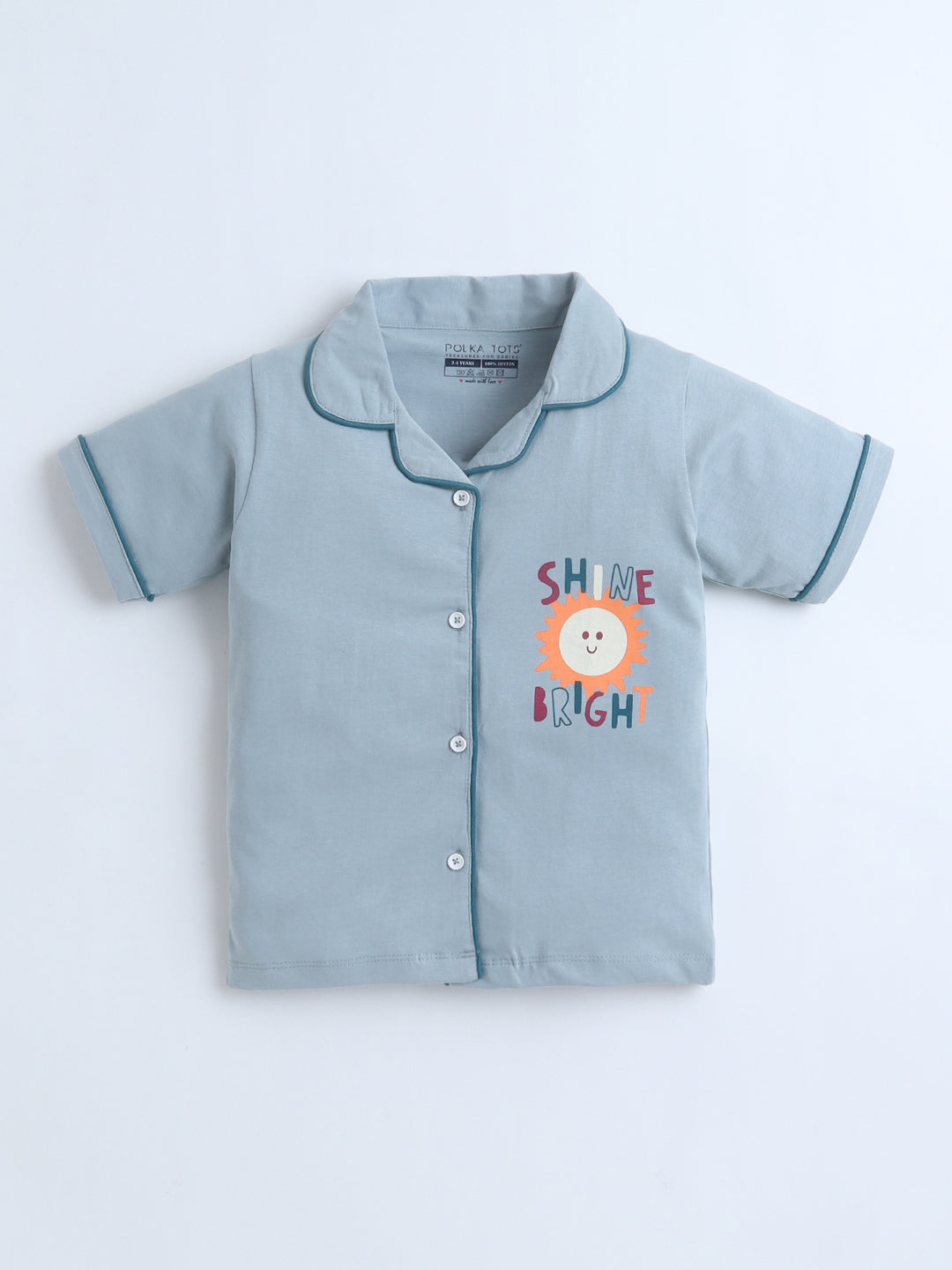 Light blue children's shirt with 'Shine Bright' text and lion graphic on a white background
