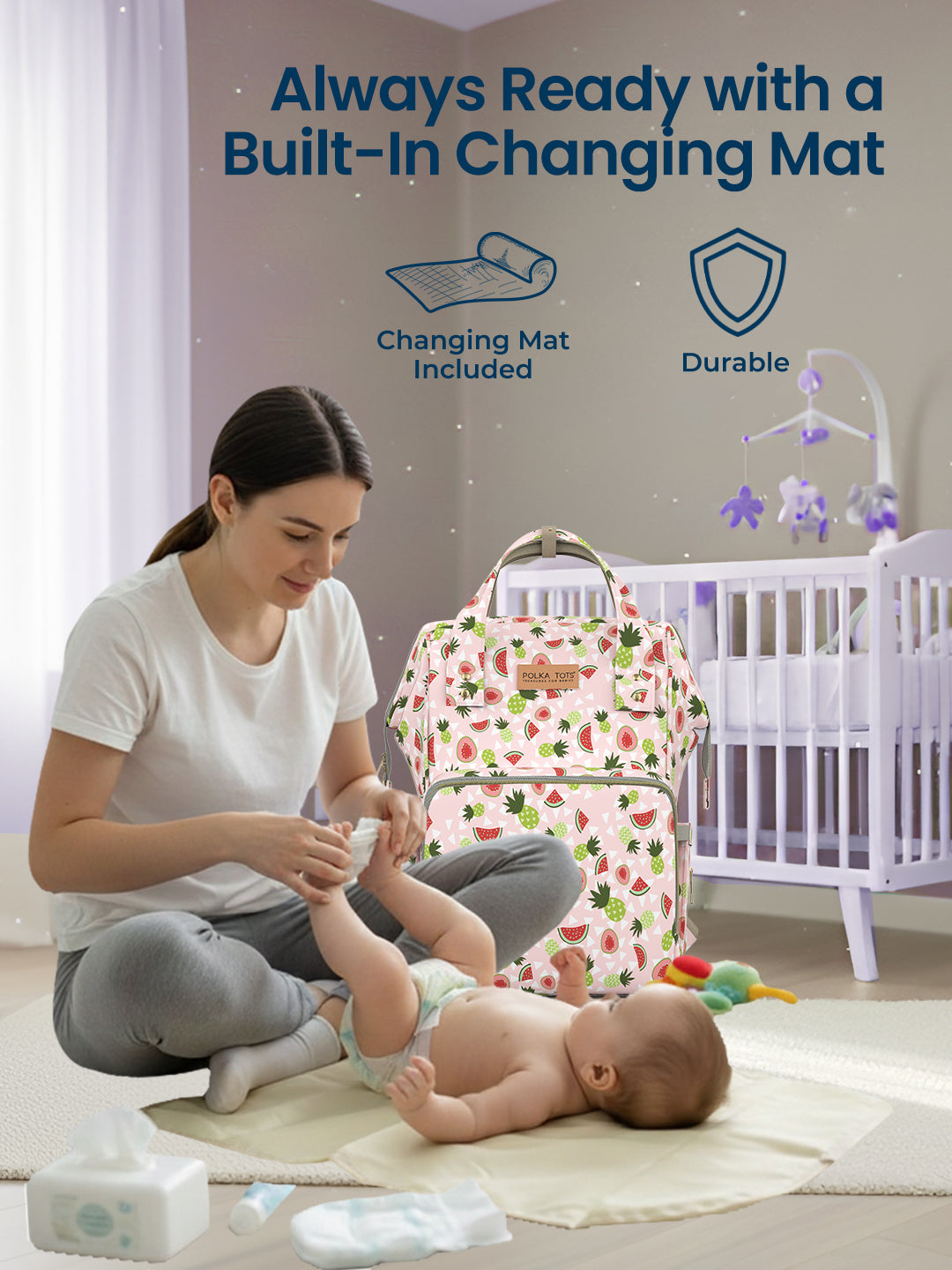 Woman changing a baby on a changing mat with a baby bag in the background