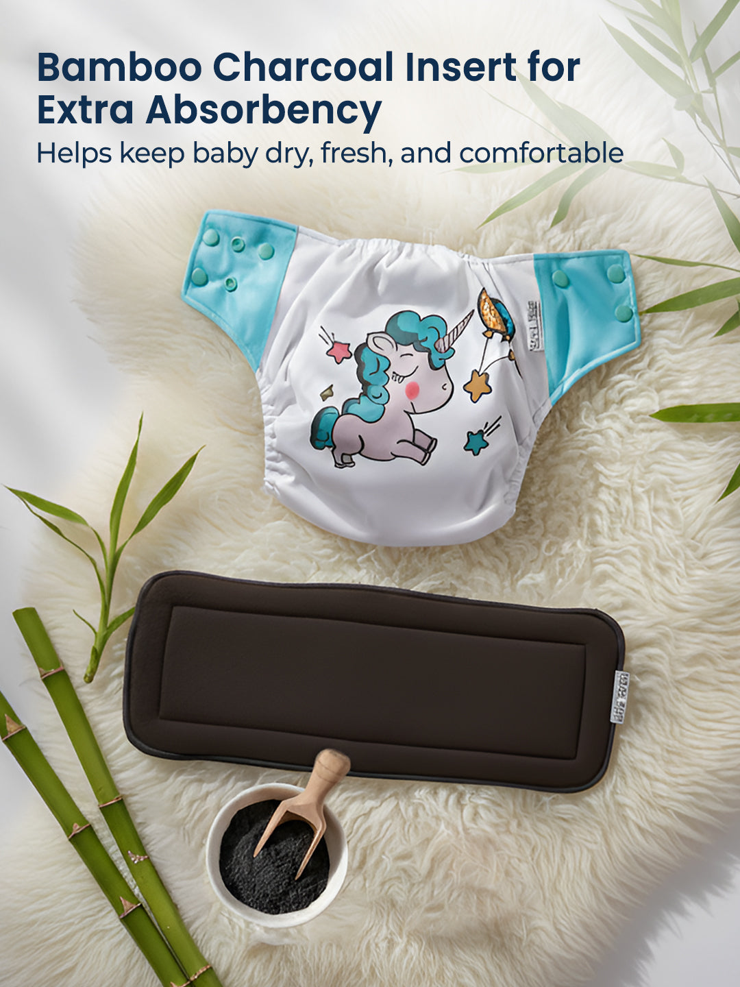 Baby diaper with unicorn design and bamboo charcoal insert on a textured surface with bamboo elements.