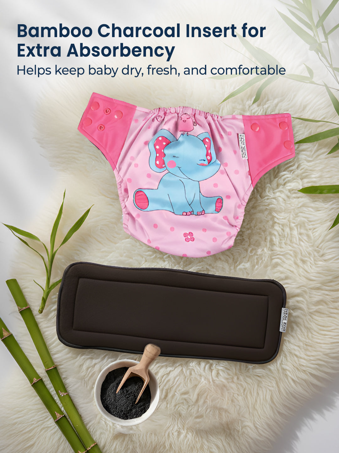 Pink diaper with elephant design and bamboo charcoal insert on a textured surface.