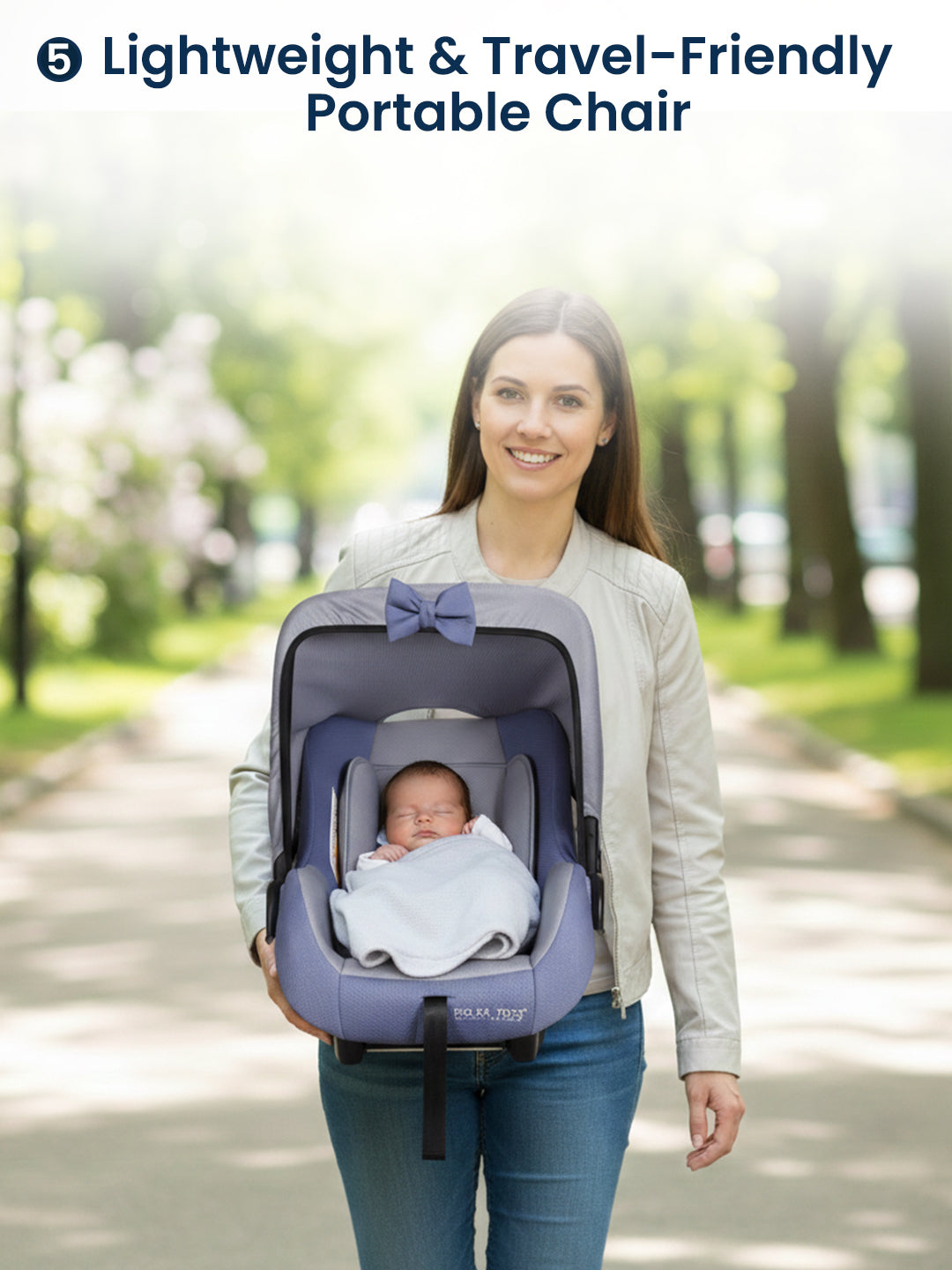 Woman carrying a baby in a portable chair with a park background