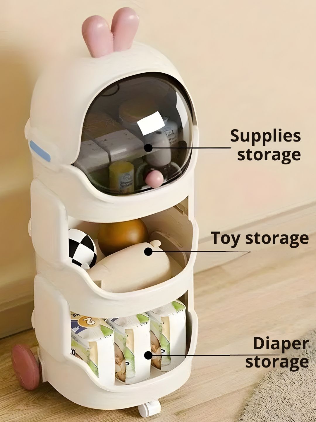 Three-tiered storage organizer with labeled sections for supplies, toys, and diapers on a wooden floor.
