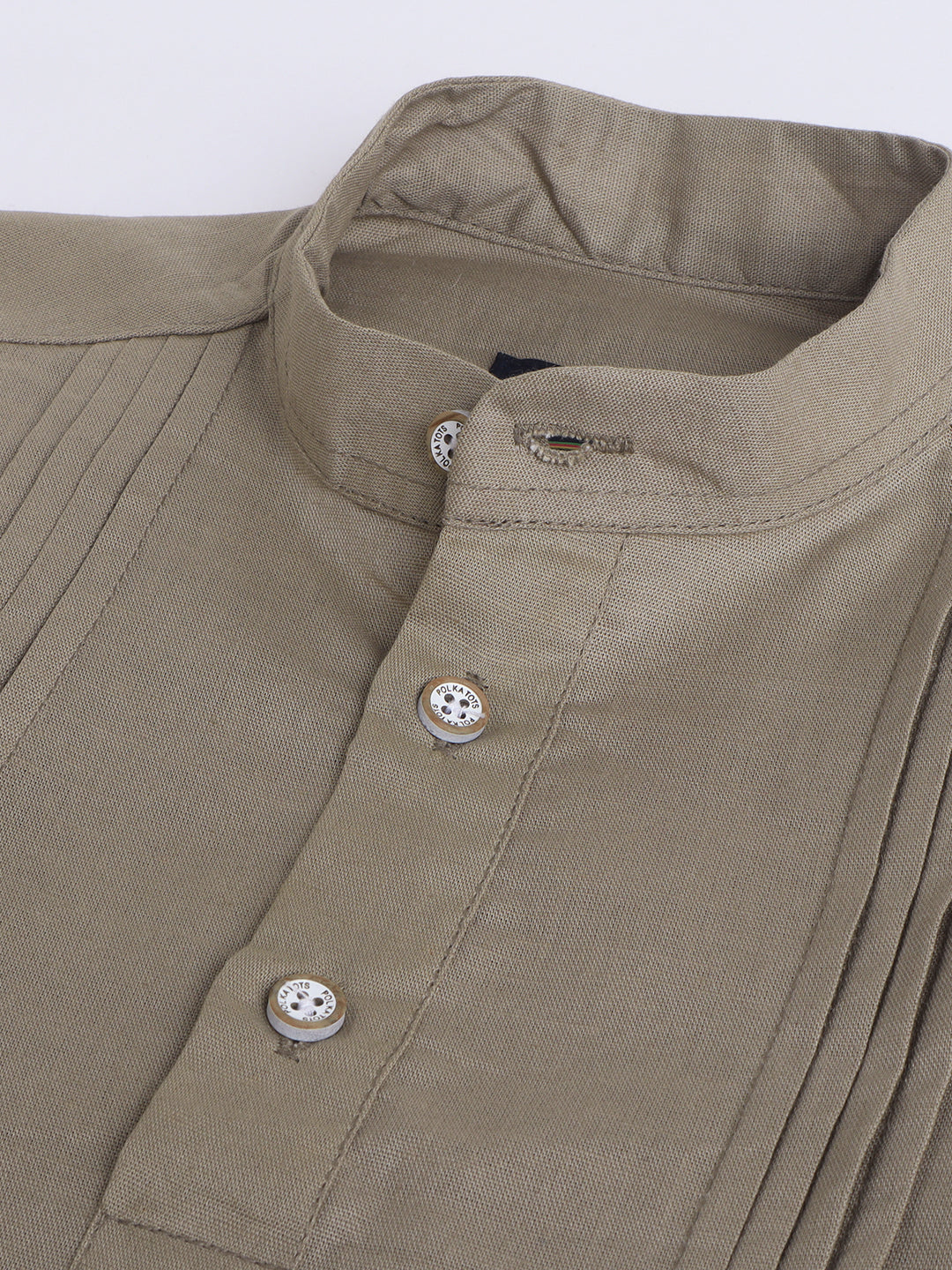 Close-up of a beige shirt with buttons on a white background