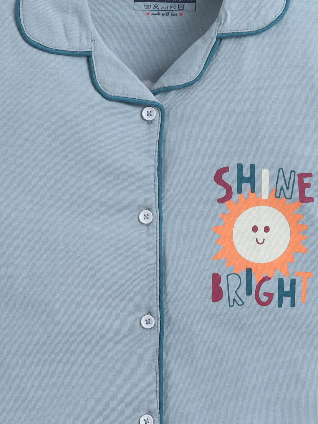 Light blue pajama top with 'Shine Bright' text and sun graphic