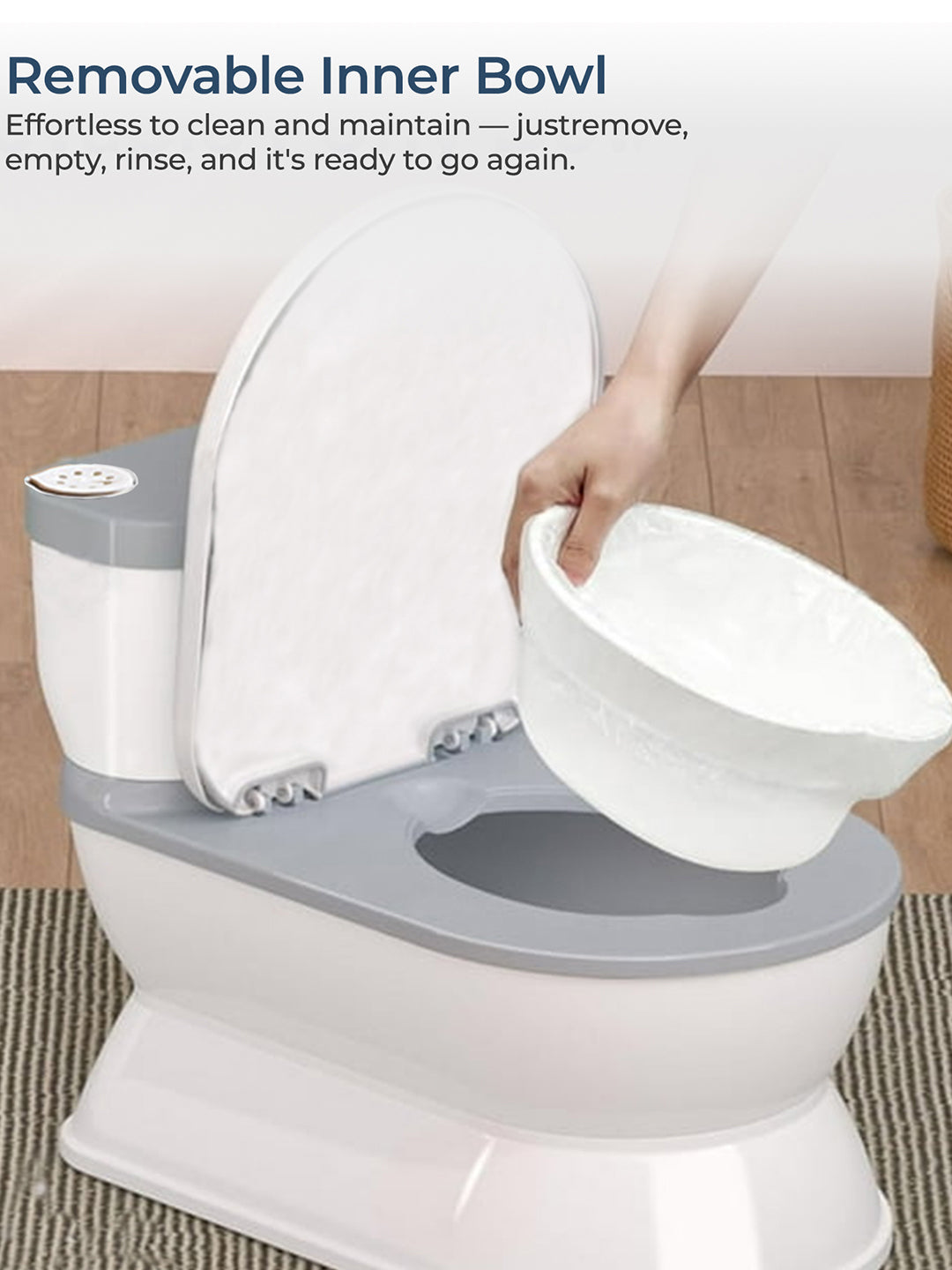 Toilet with a removable inner bowl being held by a hand, on a wooden floor.