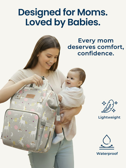 Woman holding a baby and a patterned bag with text 'Designed for Moms. Loved by Babies.'
