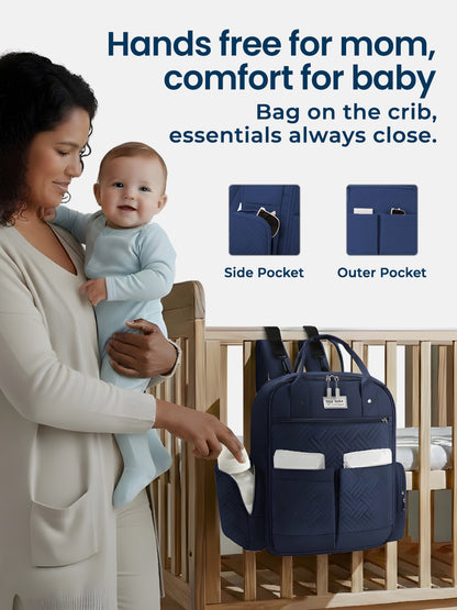 Woman holding a baby next to a navy blue backpack with pockets, text 'Hands free for mom, comfort for baby'.