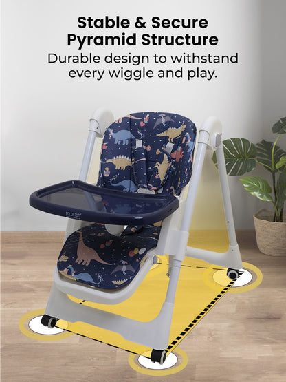 High chair with dinosaur pattern on a wooden floor with a plant in the background