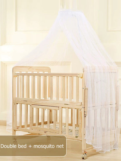 Wooden crib with a mosquito net in a room with light-colored walls.