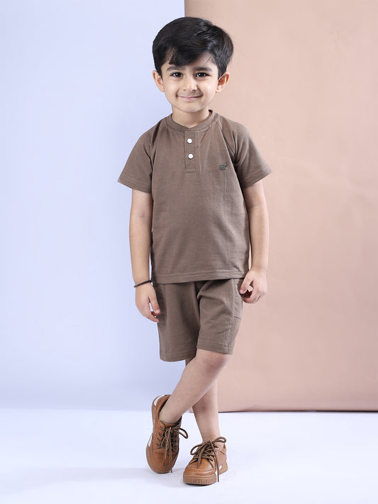 Child wearing a brown outfit with a plain background
