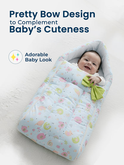 Baby wrapped in a colorful blanket with a green bow, on a light background