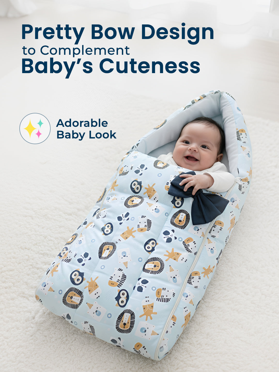 Baby wrapped in a patterned blanket with a bow, sitting on a white surface. Adorable Baby Look branding visible.