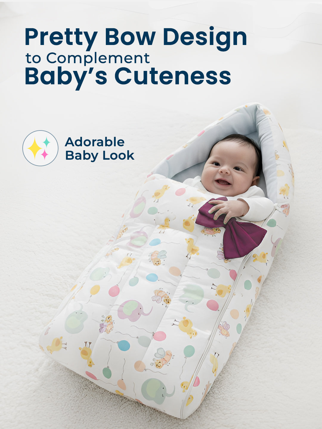 Baby wrapped in a colorful blanket with a bow, sitting on a white surface.