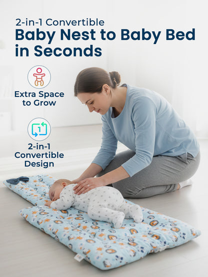 Woman with a baby on a 2-in-1 convertible baby nest and bed in a minimalistic room.