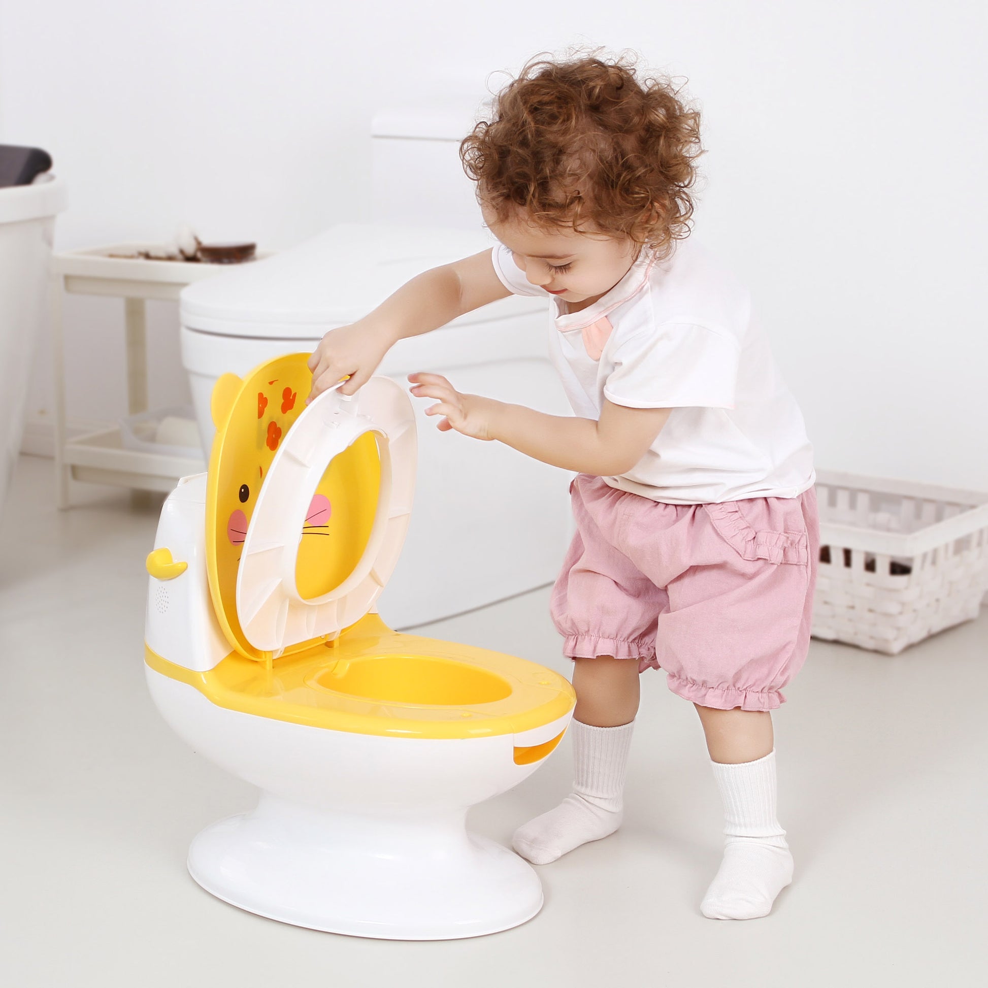 baby opening lid of yellow toilet seat 